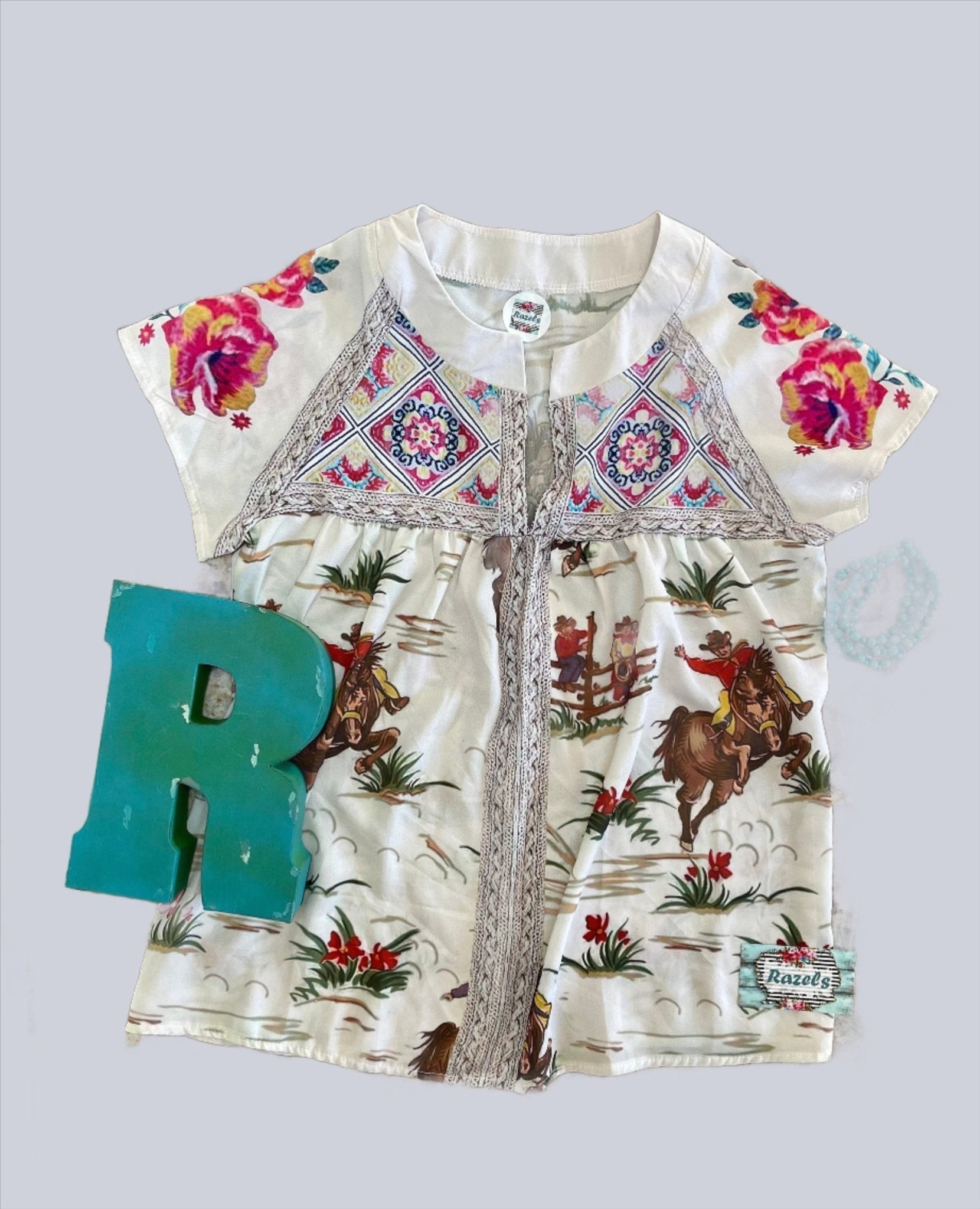 Short-sleeve shirt with floral and cowboy print on a light gray background